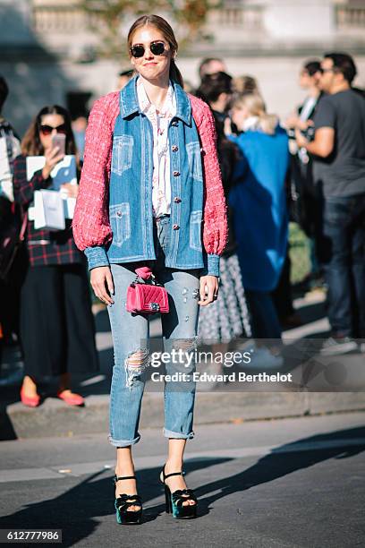 Chiara Ferragni is wearing blue denim jeans, a pink and blue denim jacket, and a pink Chanel bag, outside the Chanel show, during Paris Fashion Week...