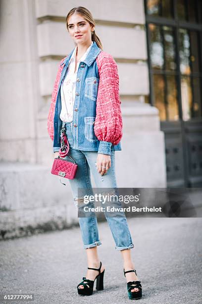 Chiara Ferragni is wearing blue denim jeans, a pink and blue denim jacket, and a pink Chanel bag, outside the Chanel show, during Paris Fashion Week...