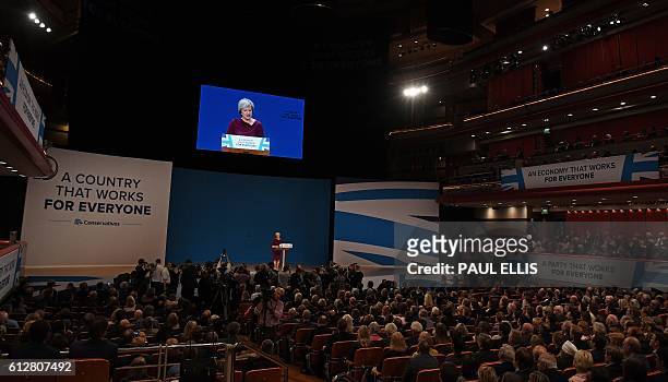 British Prime Minister Theresa May stands on the stage as she delivers a keynote address on the final day of the annual Conservative Party conference...