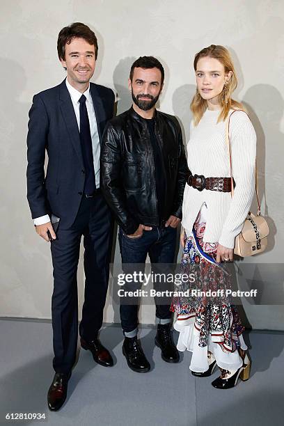 Stylist Nicolas Ghesquiere standing between General manager of Berluti Antoine Arnault and Natalia Vodianova pose after the Louis Vuitton show as...