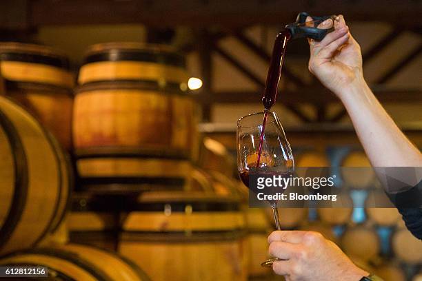 Friedrich Wilhelm Becker, co-owner of the Weingut Friedrich Becker Estate, uses a pipette to fill a glass of pinot noir wine, also known as...