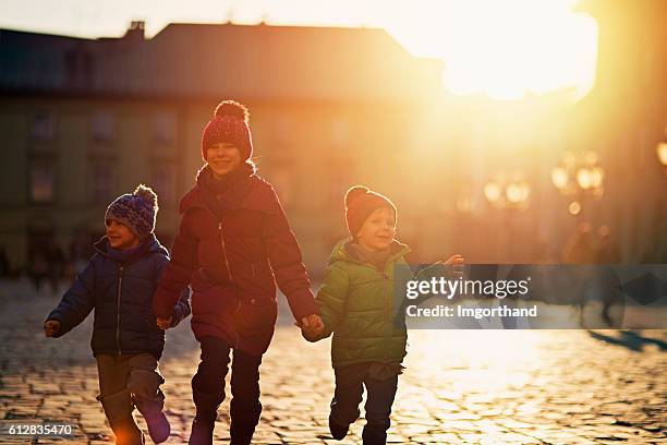 drei kinder besuchen krakauer altstadt im herbst - marktplatz stock-fotos und bilder