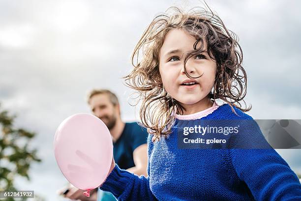 glücklich schöne kleine mädchen mit rosa ballon suchen - kid thinking stock-fotos und bilder