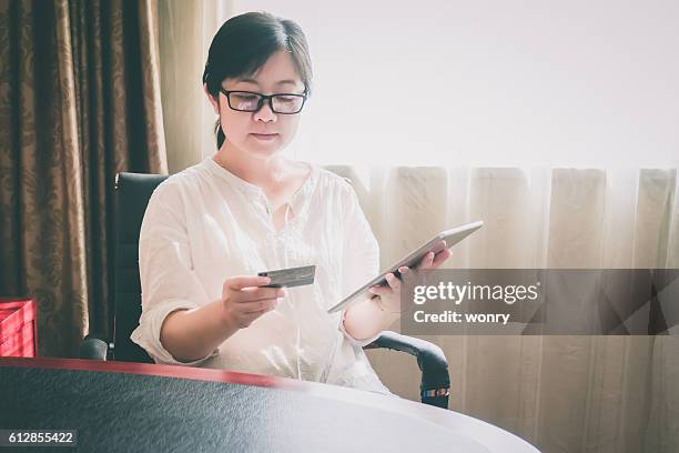 businesswoman einkaufen im hotelzimmer - man in suite holding tablet stock-fotos und bilder