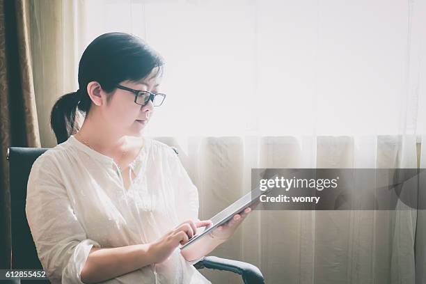 geschäftsfrau mit digitalem tablet in innenräumen - man in suite holding tablet stock-fotos und bilder