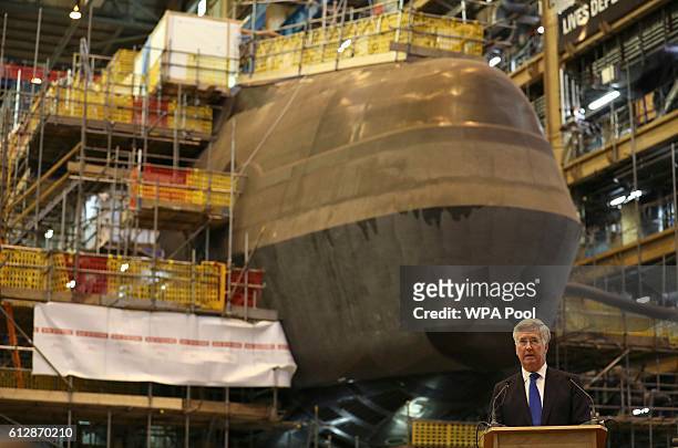 Britain's Defence Secretary Michael Fallon speaks to workers after watching the first piece of steel for the successor submarine programme being cut...