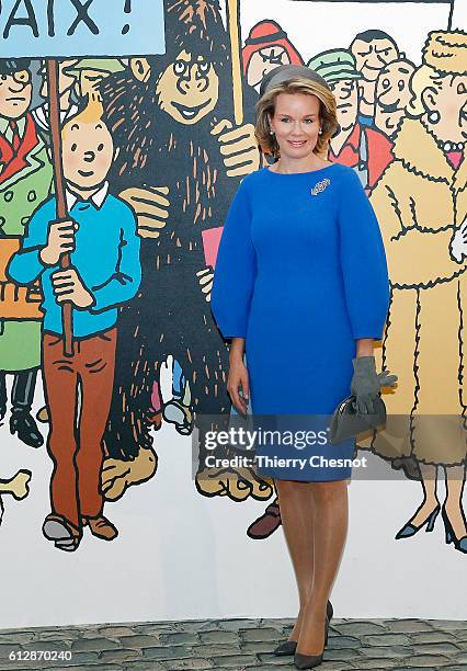 Queen Mathilde of Belgium poses for photos in front of a mural of comic characters from the comic book series Tintin on October 5, 2016 in Paris,...