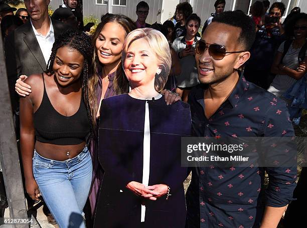 Model and television personality Chrissy Teigen and singer/songwriter John Legend pose with a cardboard cutout of Democratic presidential nominee...