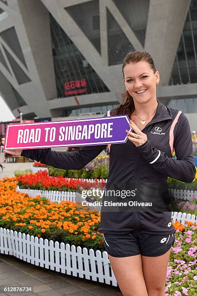 Agnieszka Radwanska of Poland holds a 'Road to Singapore' sign after she secured her qualification for the BNP Paribas WTA Finals in Singapore...