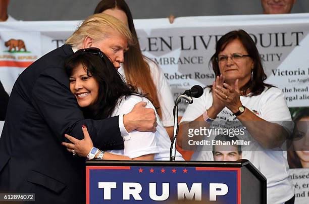 Republican presidential nominee Donald Trump hugs Ruth Johnston-Martin after she spoke about her late husband Don Johnston, an officer with the El...
