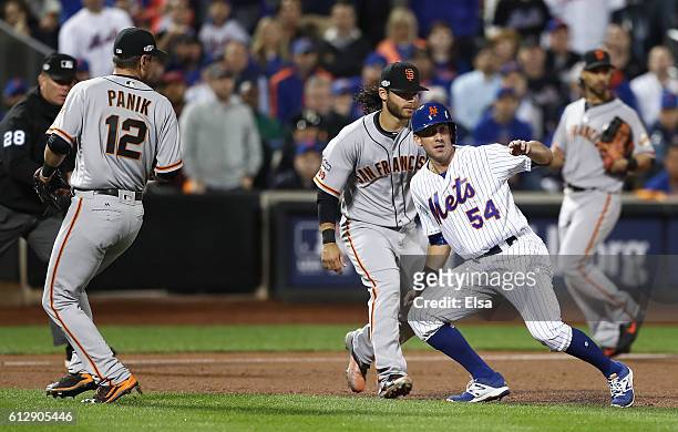 Rivera of the New York Mets is caught in a rundown by Joe Panik and Brandon Crawford of the San Francisco Giants in the fifth inning during their...