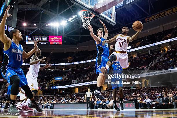 Markel Brown of the Cleveland Cavaliers passes around Stephen Zimmerman Jr. #33 of the Orlando Magic during the second half of a preseason game at...