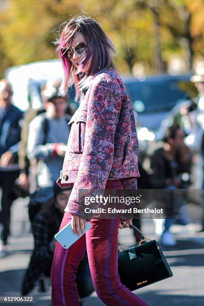 Guest is wearing a purple full outfit, and is posing in front of the photographers, outside the Miu Miu show, during Paris Fashion Week Spring Summer...