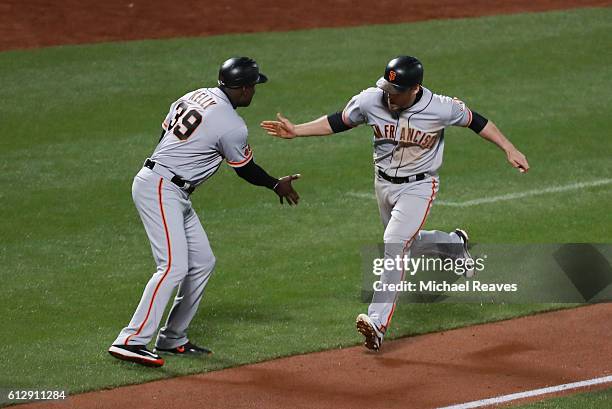 Conor Gillaspie celebrates with third base coach Roberto Kelly of the San Francisco Giants as he runs the bases after hitting a three-run homerun in...