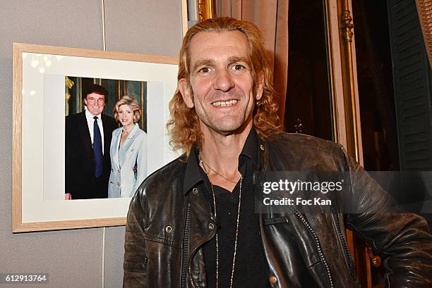 Photographer Ale de Basseville poses with a portrait of Donald Trump during the Massimo Gargia's Photos of Celebrities Exhibition at Mairie du 8eme -...