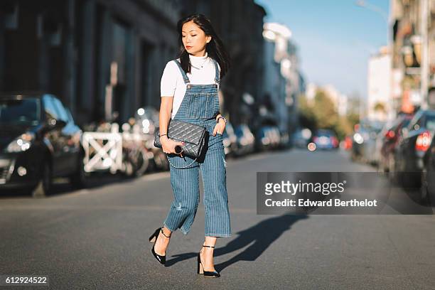 May Berthelot is wearing a Zara blue denim overall, a Courreges top, Valentino Tango shoes, a Chanel blue bag, during Parsi Fashion Week Spring...