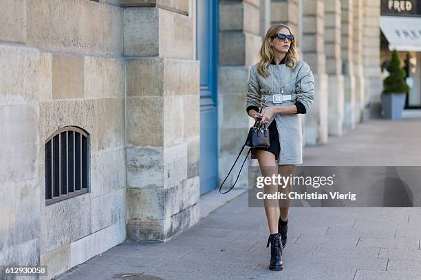 Elena Perminova wearing a coat, belt, and Prada mini bag outside Louis Vuitton on October 5, 2016 in Paris, France.