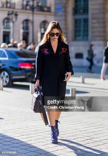 Miroslava Duma wearing a black coat and Louis Vuitton bag outside Louis Vuitton on October 5, 2016 in Paris, France.