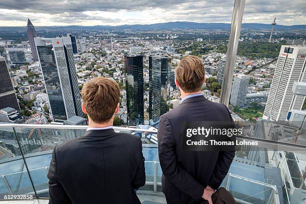 Two men stand at the viewing platform of the 'Maintower' and look to the headquarters of Deutsche Bank on October 5, 2016 in Frankfurt, Germany....