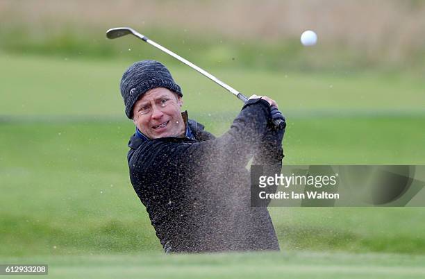 Actor Greg Kinnear plays out from bunker on the 13th hole during the first round of the Alfred Dunhill Links Championship on the Championship Course,...