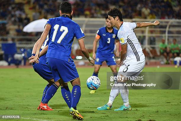 Masato Morishige of Japan shoots the ball under the pressure from Weerawaatnodom Narubadin and Kesarat Tanaboon of Thailand during the 2018 FIFA...