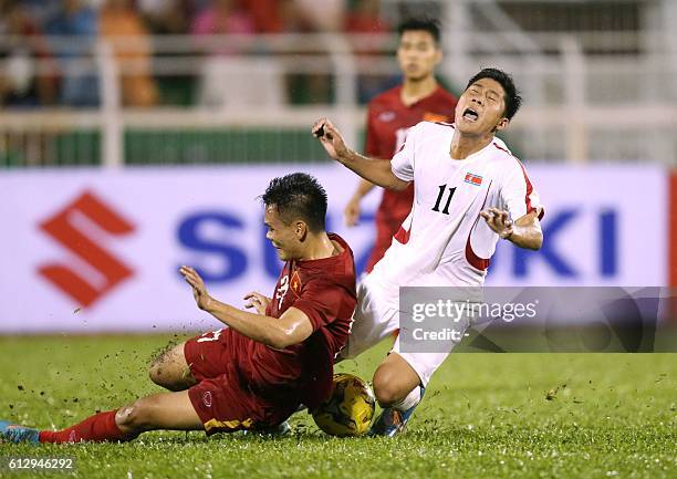 North Korea's Jong Il Gwan fights for the ball with Vietnam's Luong Xuan Truong during a friendly match in Ho Chi Minh City on October 6, 2016....