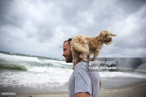Ted Houston and his dog Kermit visit the beach as Hurricane Matthew approaches the area on October 6, 2016 in Palm Beach, United States. The...