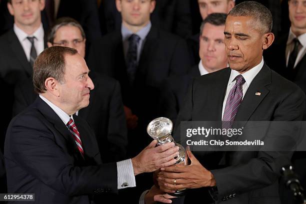 National Hockey League Commissioner Gary Bettman presents U.S. President Barack Obama with a miniature replica of the Stanley Cup while celebrating...