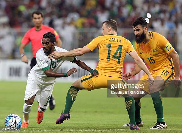 Saudi's Nawaf Alabid dribbles past Australia's Brad Smith during the 2018 FIFA World Cup Qualifiers match between Saudi Arabia and Australia at the...