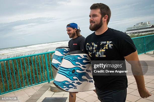 Shane Reed and Jon Anderson walk along the Daytona Beach Boardwalk carrying boogie boards, October 6, 2016 in Daytona Beach, Florida. With Hurricane...