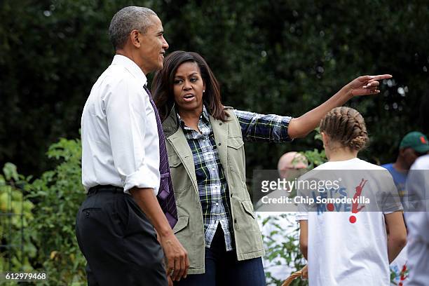 First lady Michelle Obama shows President Barack Obama the progess made during a harvesting event in the White House Kitchen Garden on the South Lawn...