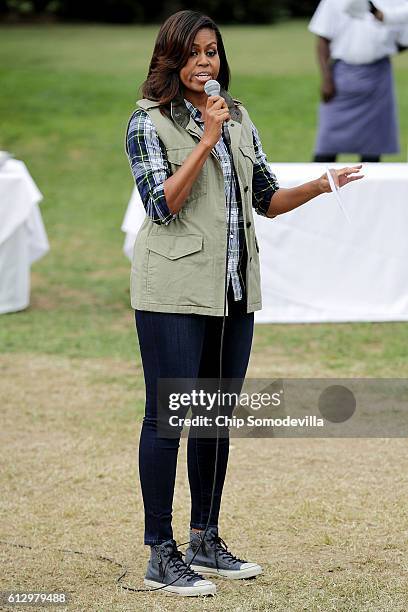 First lady Michelle Obama speaks to students and guests during a harvesting event at White House Kitchen Garden on the South Lawn of the White House...