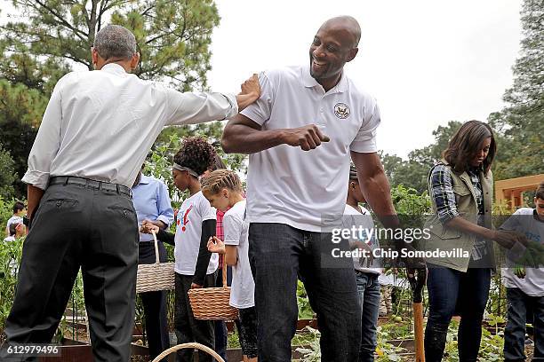 President Barack Obama jokes with Alonzo Mourning, former NBA All-Star and member of the President's Council on Fitness, during an event to harvest...