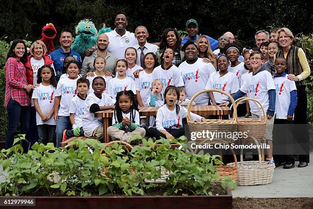 First lady Michelle Obama and President Barack Obama pose for a group photograph during an event to harvest the White House Kitchen Garden on the...