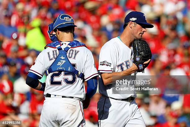 Cole Hamels of the Texas Rangers reacts with teammate Jonathan Lucroy on the mound against the Toronto Blue Jays during the third inning in game one...
