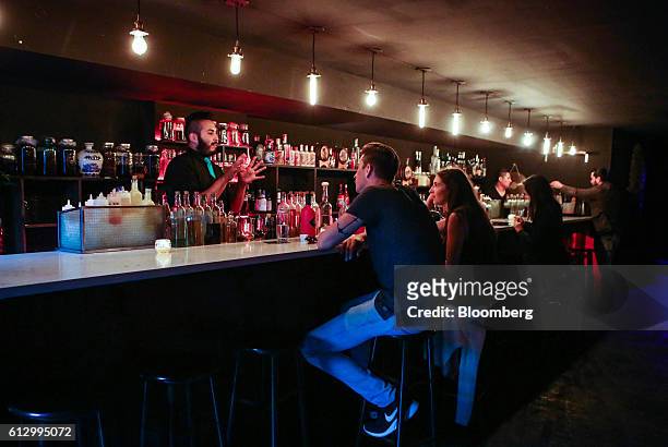 Bartender, left, speaks with customers at Bar Lumos, which serves 40 different brands of baijiu, in New York, U.S., on Tuesday, Sept. 27, 2016. With...