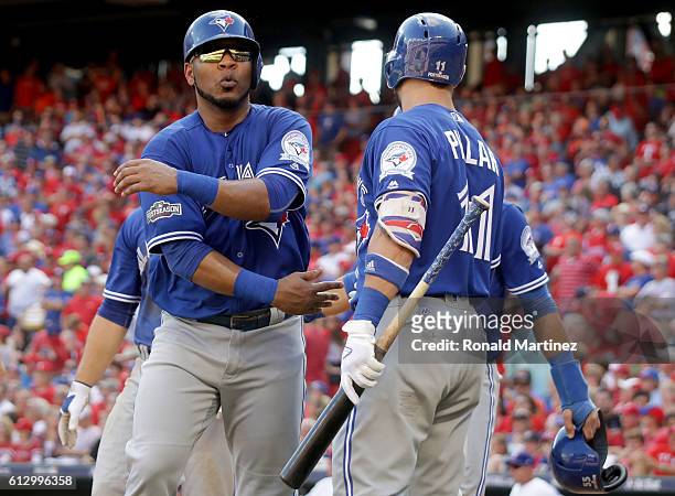 Edwin Encarnacion of the Toronto Blue Jays celebrates with his teammates after scoring a run off of Troy Tulowitzki RBI triple to right field against...