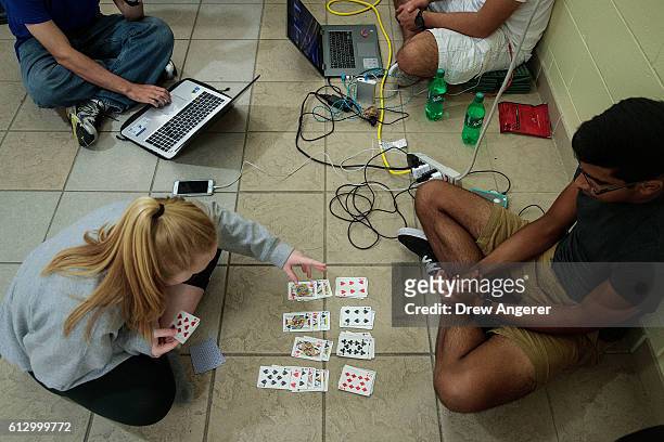 Embry-Riddle Aeronautical University students pass the time by playing cards at public shelter set up at Mainland High School, October 6, 2016 in...