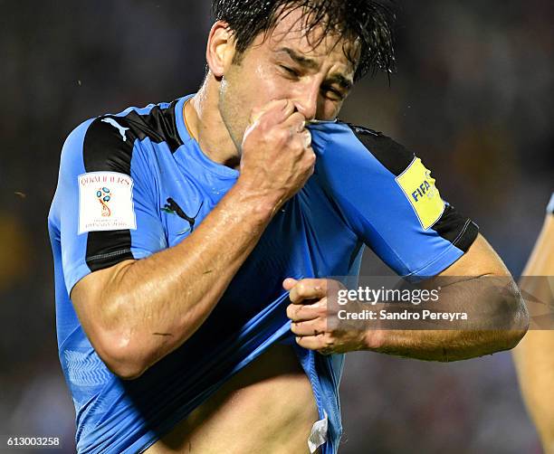 Nicolas Lodeiro of Uruguay celebrates and kisses his jersey after scoring the fist goal of his team during a match between Uruguay and Venezuela as...