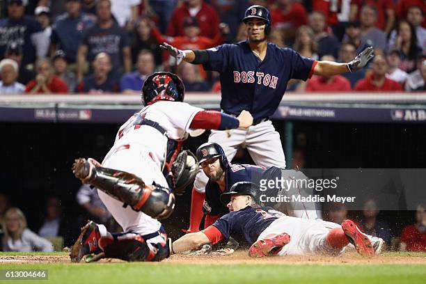 Brock Holt of the Boston Red Sox is called out at home plate after Dustin Pedroia scored a run in the first inning against the Cleveland Indians...