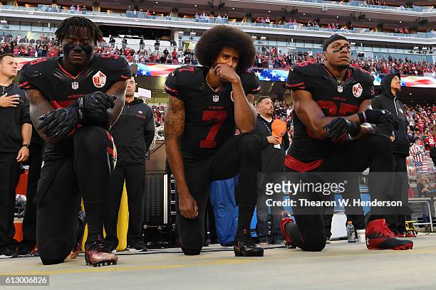 Eli Harold, Colin Kaepernick, and Eric Reid of the San Francisco 49ers kneel in protest during the national anthem prior to their NFL game against...