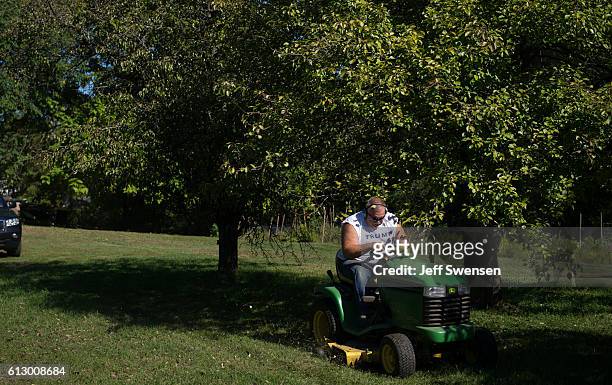 Vince Hrubes a retired steelworker, spent 45 years as a registered democrat, but switched parties 6 months ago, mows his lawn in Youngstown,...