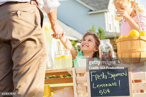 happy girl sells lemonade to a customer - small town america stock pictures, royalty-free photos & images