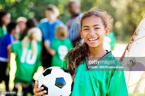 une fille heureuse sourit après avoir gagné un match de football - fille sport photos et images de collection