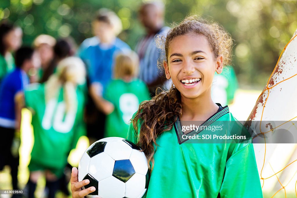 Happy girl smiles after winning soccer game