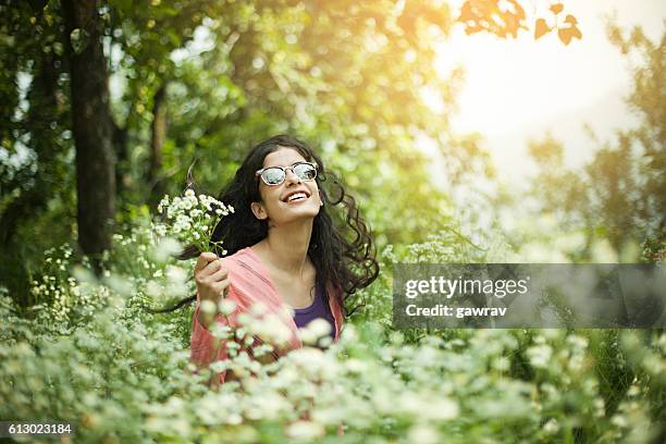retrato de la hermosa chica asiática en prado de retención de flores silvestres. - largo florida fotografías e imágenes de stock