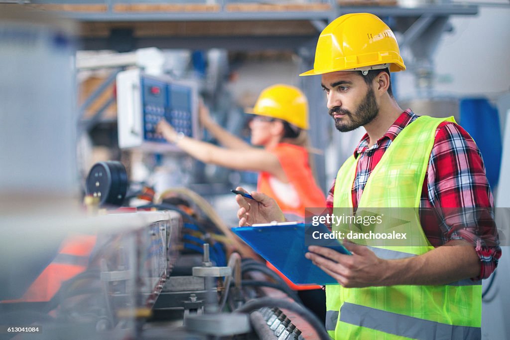 Male worker in factory taking notes