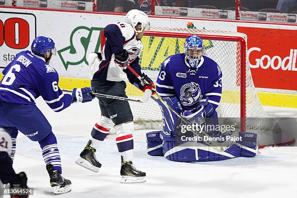 Goaltender Matthew Mancina of the Mississauga Steelheads makes a huge save on a deflection from forward Jeremiah Addison of the Windsor Spitfires on...