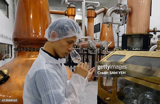 This picture taken on September 9, 2016 shows an employee of Kavalan whisky smelling the whisky at the companies production facility in Yilan, in the...