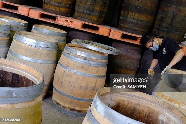 This picture taken on September 9, 2016 shows an employee of Kavalan whisky preparing a wooden whisky barrel at the companies production facility in...